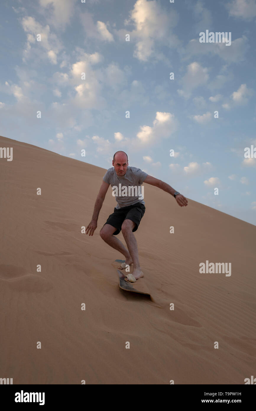 I turisti in Abu Dhabi provate sand boarding sulle dune del deserto degli EMIRATI ARABI UNITI Foto Stock