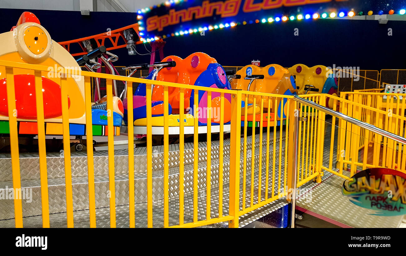 Primo piano immagine di coloratissimi auto elettriche sulla giostra nel parco divertimenti al centro commerciale per lo shopping Foto Stock