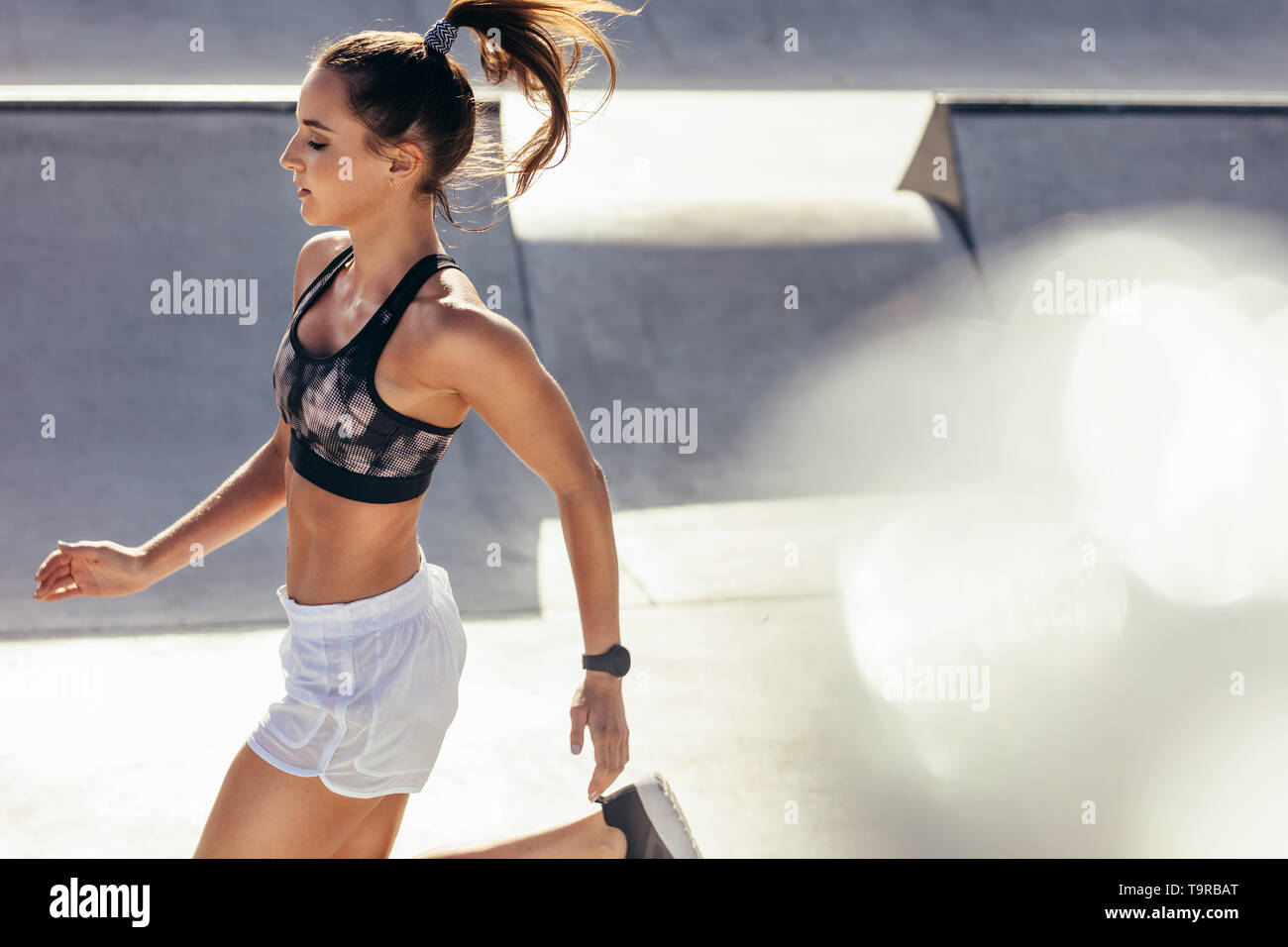 Montare la donna in esecuzione all'esterno. Sano giovane atleta femminile facendo allenamento fitness. Foto Stock