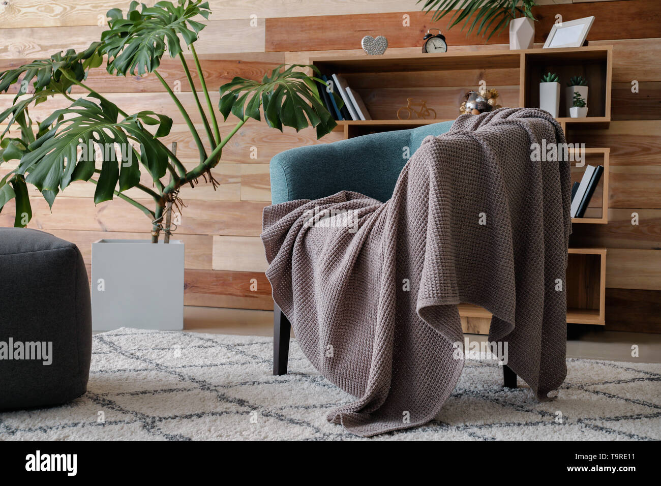 Elegante poltrona con plaid a interno della camera Foto Stock