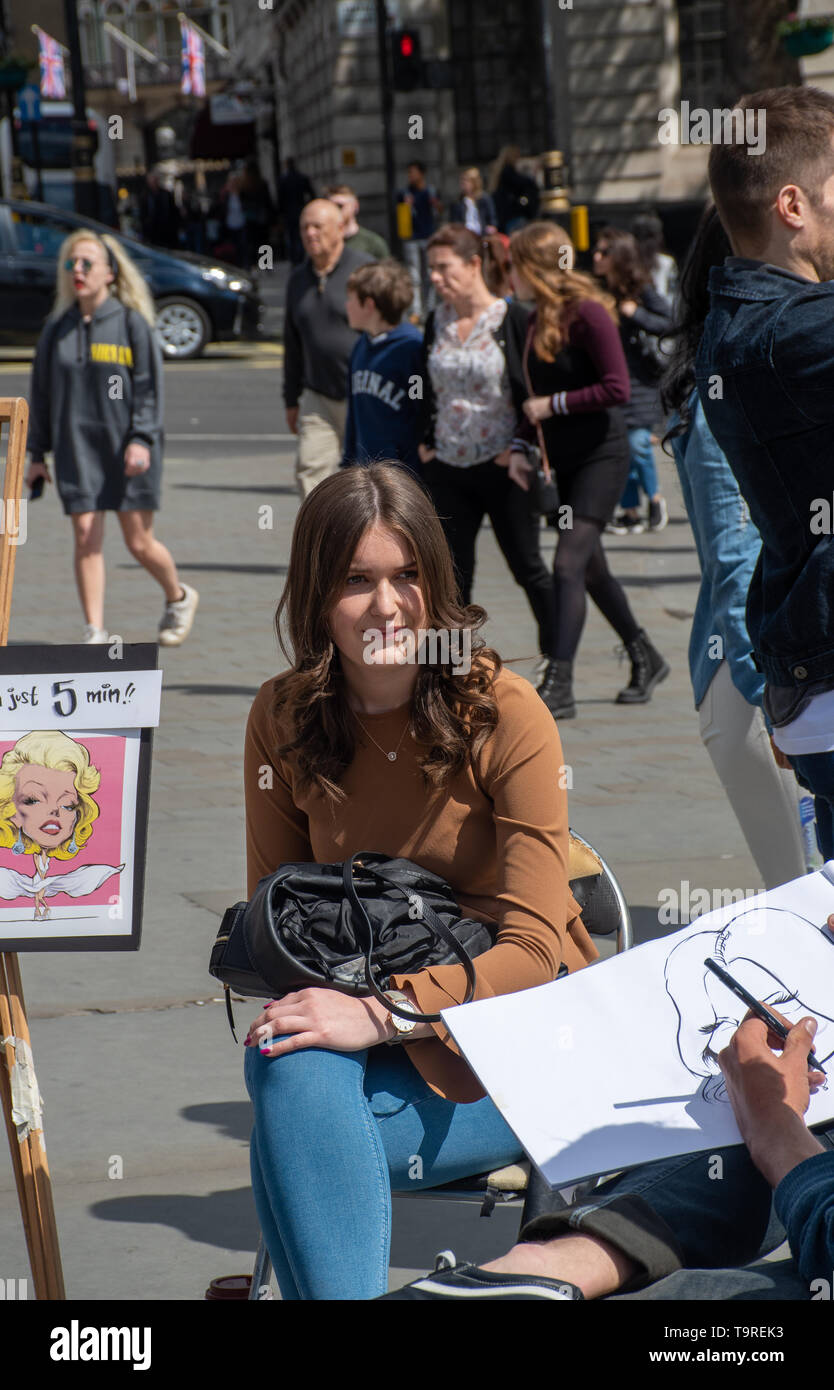 Trafalgar Square Londra Regno Unito -12 Maggio 2019: Pretty girl avente caricatura disegnato dall'artista di strada Foto Stock