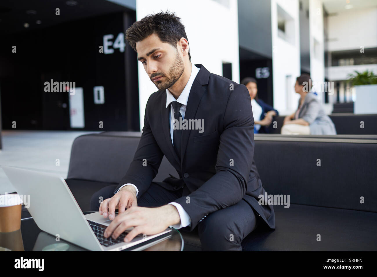 Razza mista manager esaminando i dati sul computer portatile Foto Stock