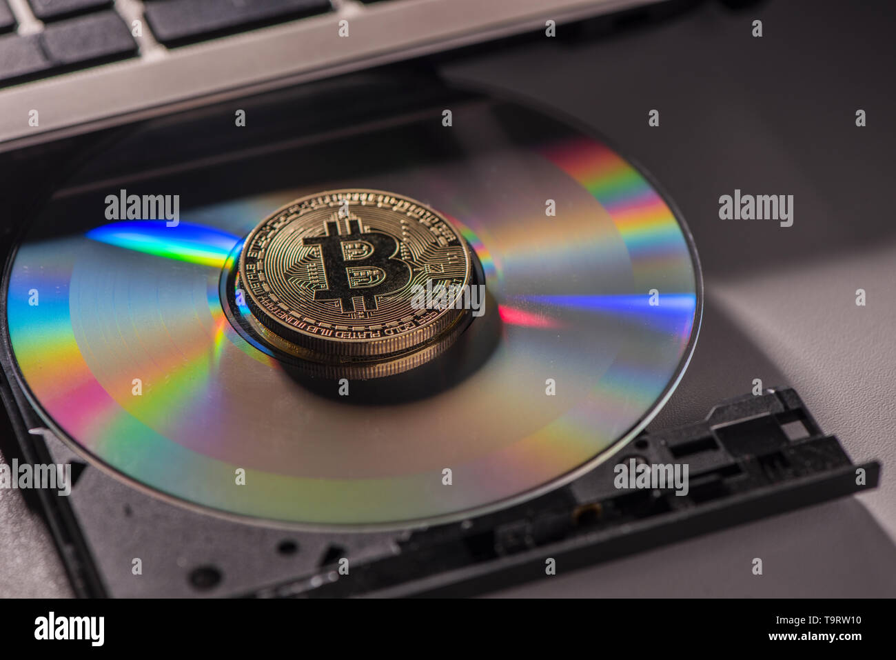 Golden Bitcoin moneta con concetto blockchain su laptop cd rom. Close up Foto Stock