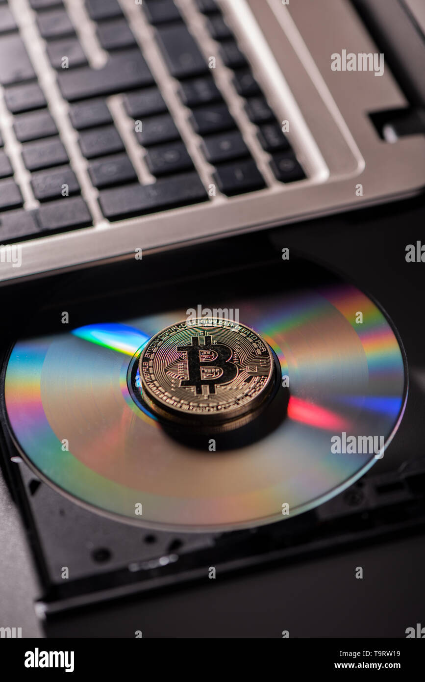 Golden Bitcoin moneta con concetto blockchain su laptop cd rom. Close up Foto Stock