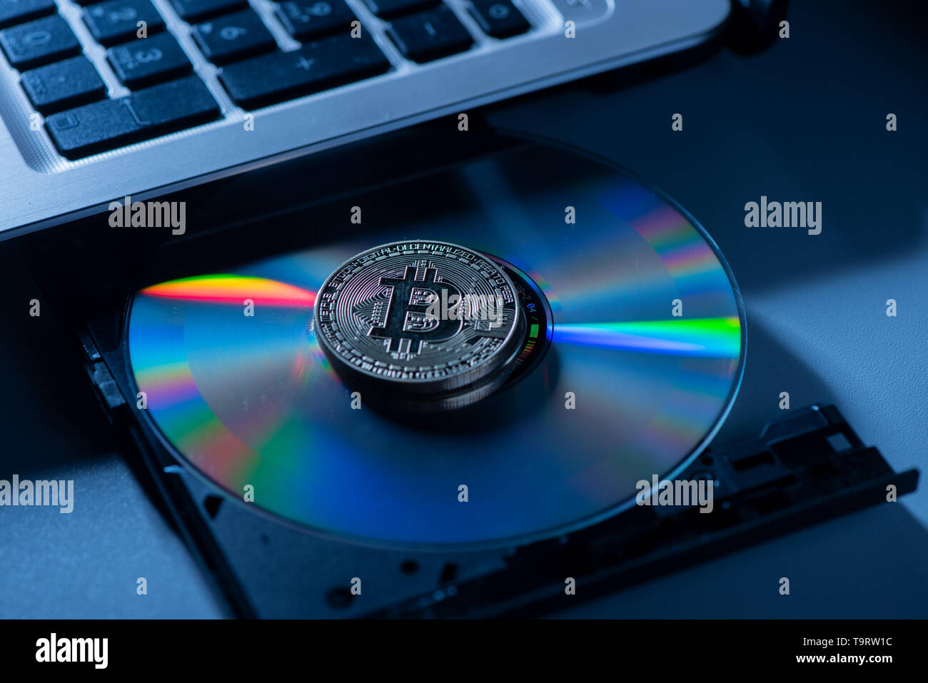 Golden Bitcoin moneta con concetto blockchain su laptop cd rom. Close up Foto Stock