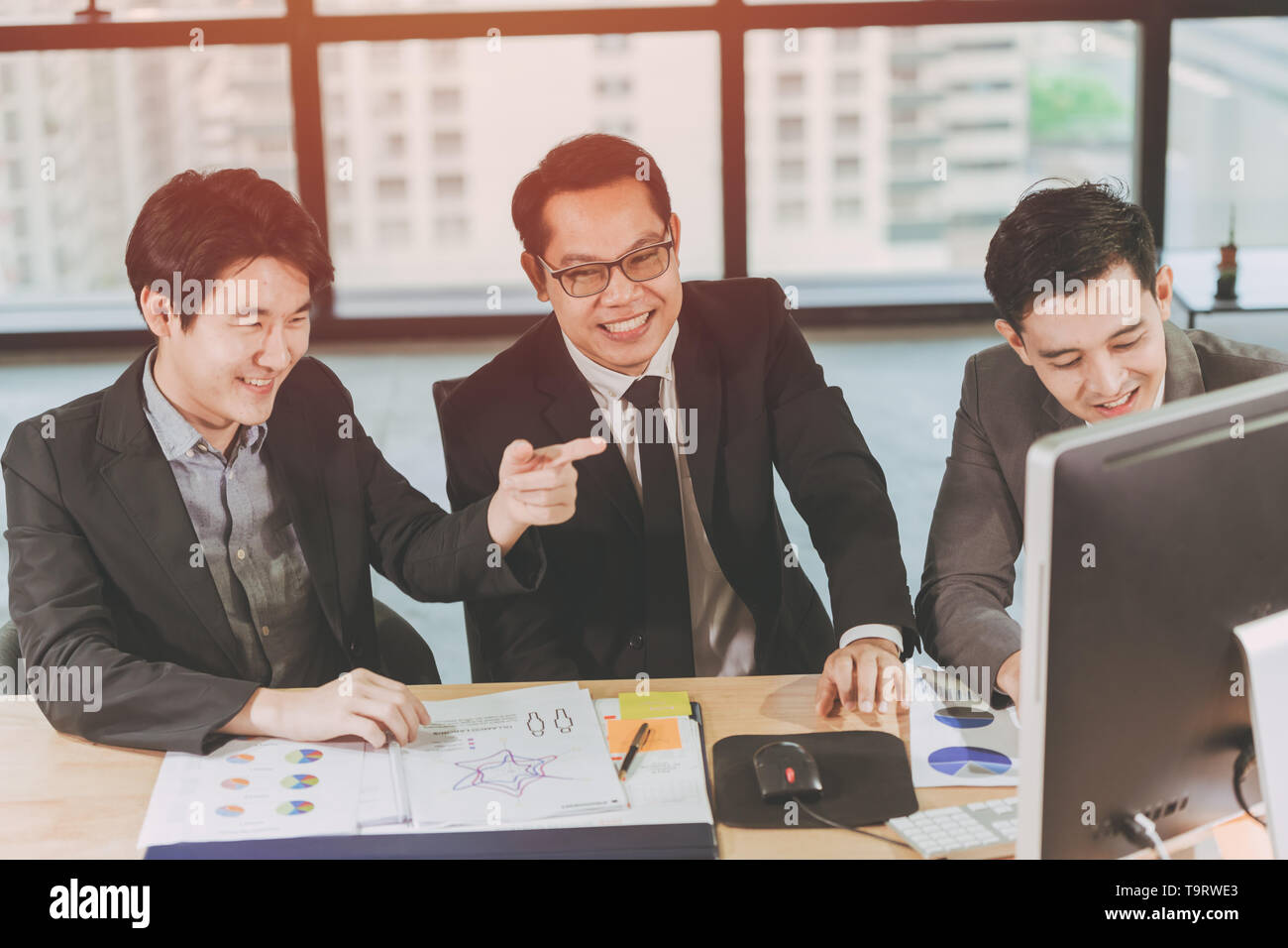 Un gruppo di uomini di affari che lavorando insieme alla scrivania con computer in ufficio,Tre imprenditore sorriso felice Coworking Concept Foto Stock