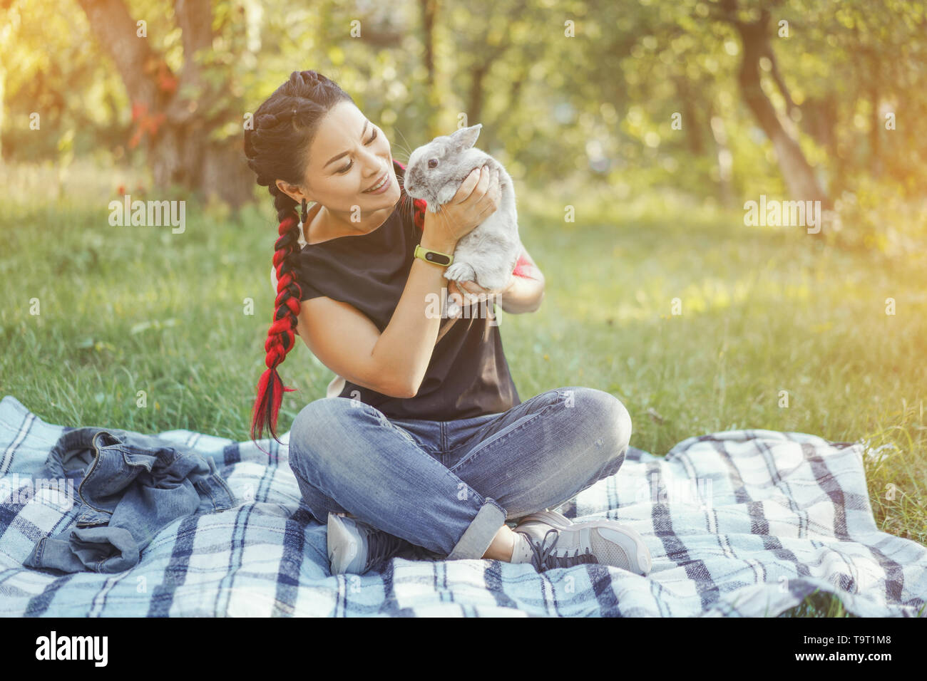 Close-up di Pretty Asian abbracciando Bunny su Estate Natura Foto Stock