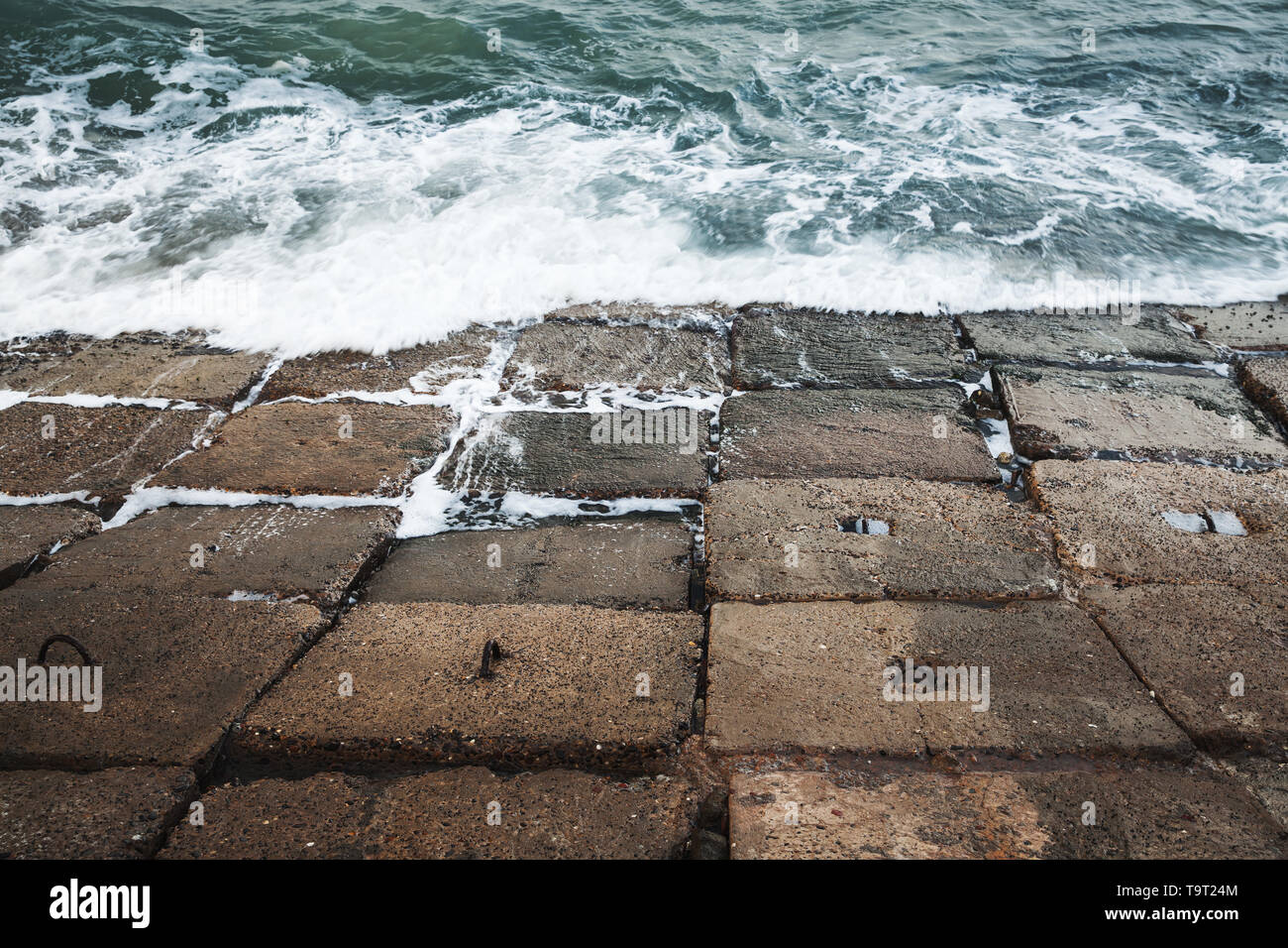 Dark calcestruzzo blocchi frangiflutti con acqua di mare tempestoso, Egitto Alessandria, Egitto Foto Stock