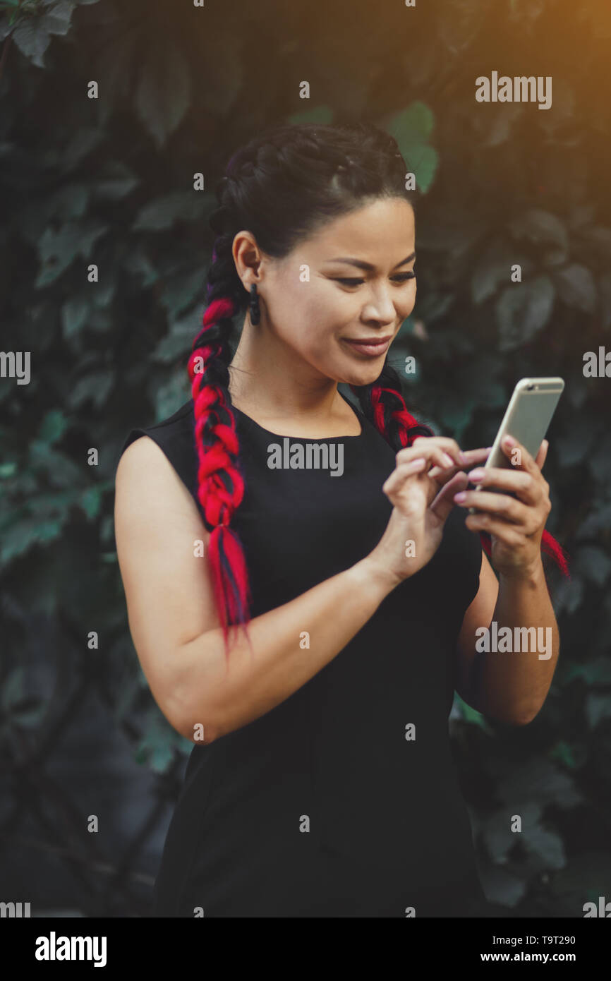 Bella coppia asiatica di modello femminile con lo smartphone per esterno Foto Stock