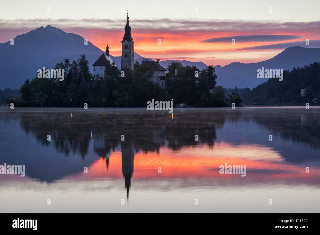 Drammatica alba sul lago di Bled, sunrise vista sul lago di Bled, isola, la Chiesa del pellegrinaggio dell Assunzione di Maria e il castello con la gamma della montagna (Stol, V Foto Stock