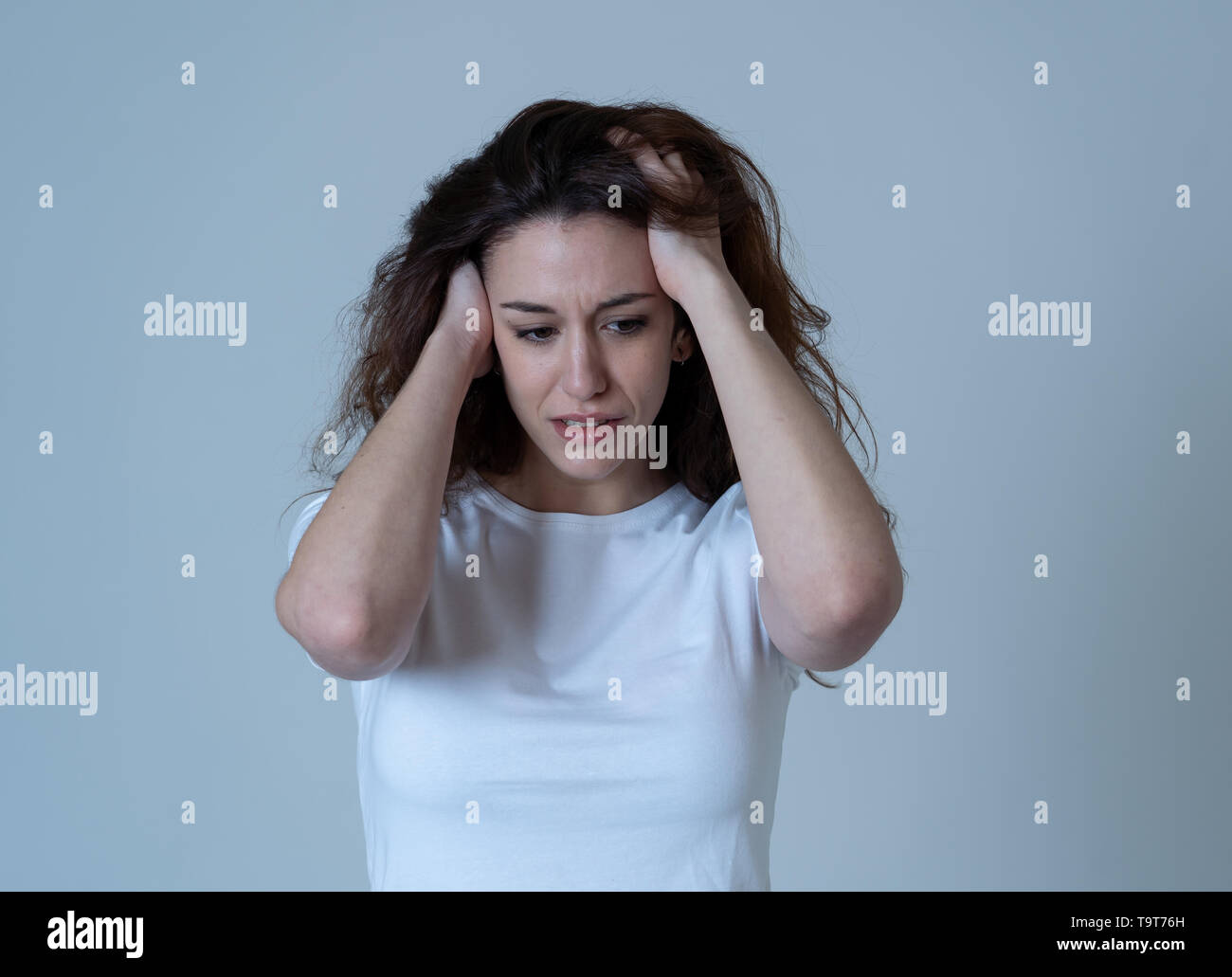 Ritratto di giovane donna triste guardando preoccupato nel dolore emotivo. Sensazione di dolore e di sofferenza dalla depressione. Isolato in uno sfondo neutro. In mentale Foto Stock