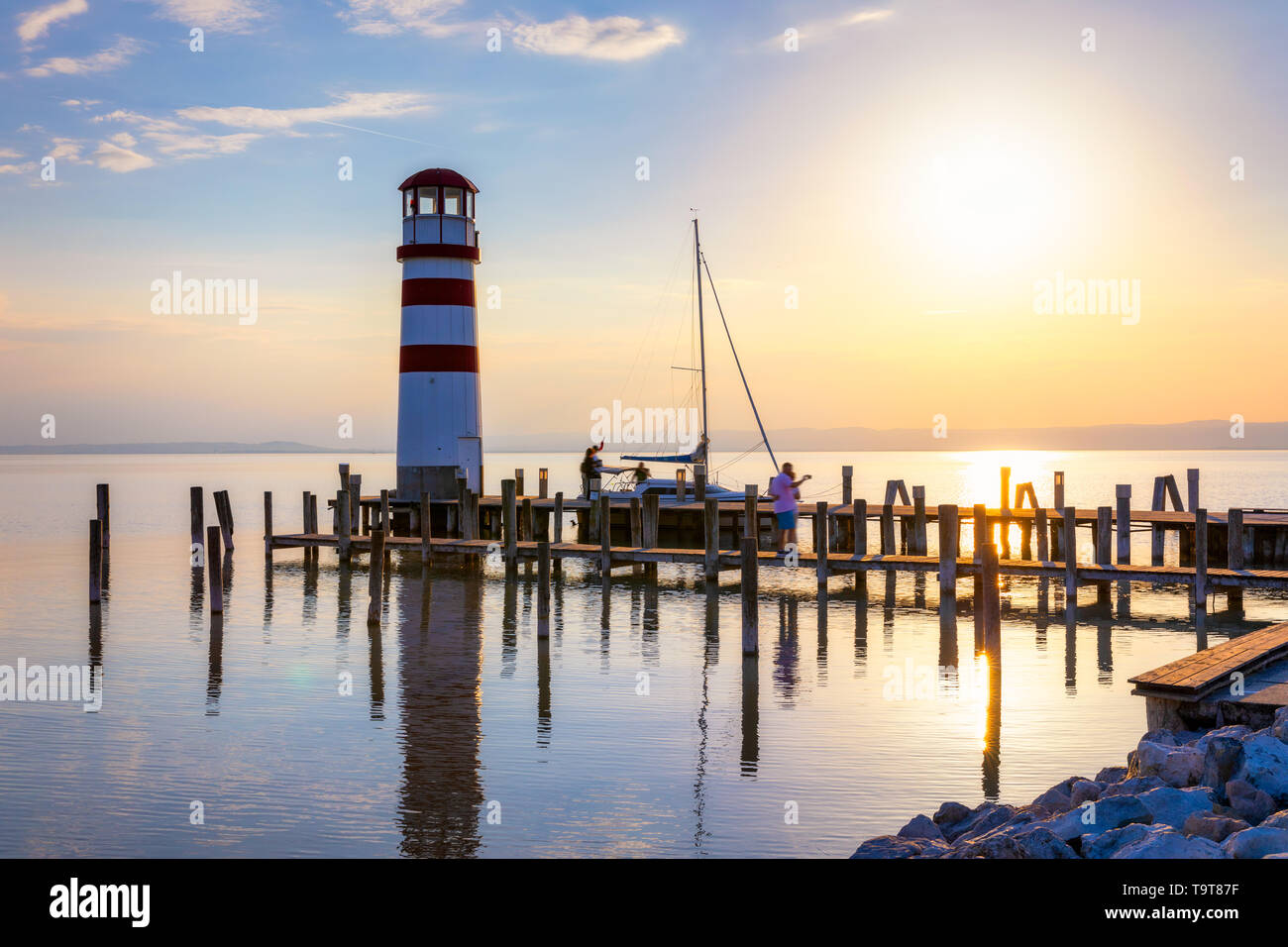 Faro di lago di Neusiedl, Podersdorf am See, Burgenland, Austria. Faro al tramonto in Austria. Il molo di legno con il faro in Podersdorf sul lak Foto Stock