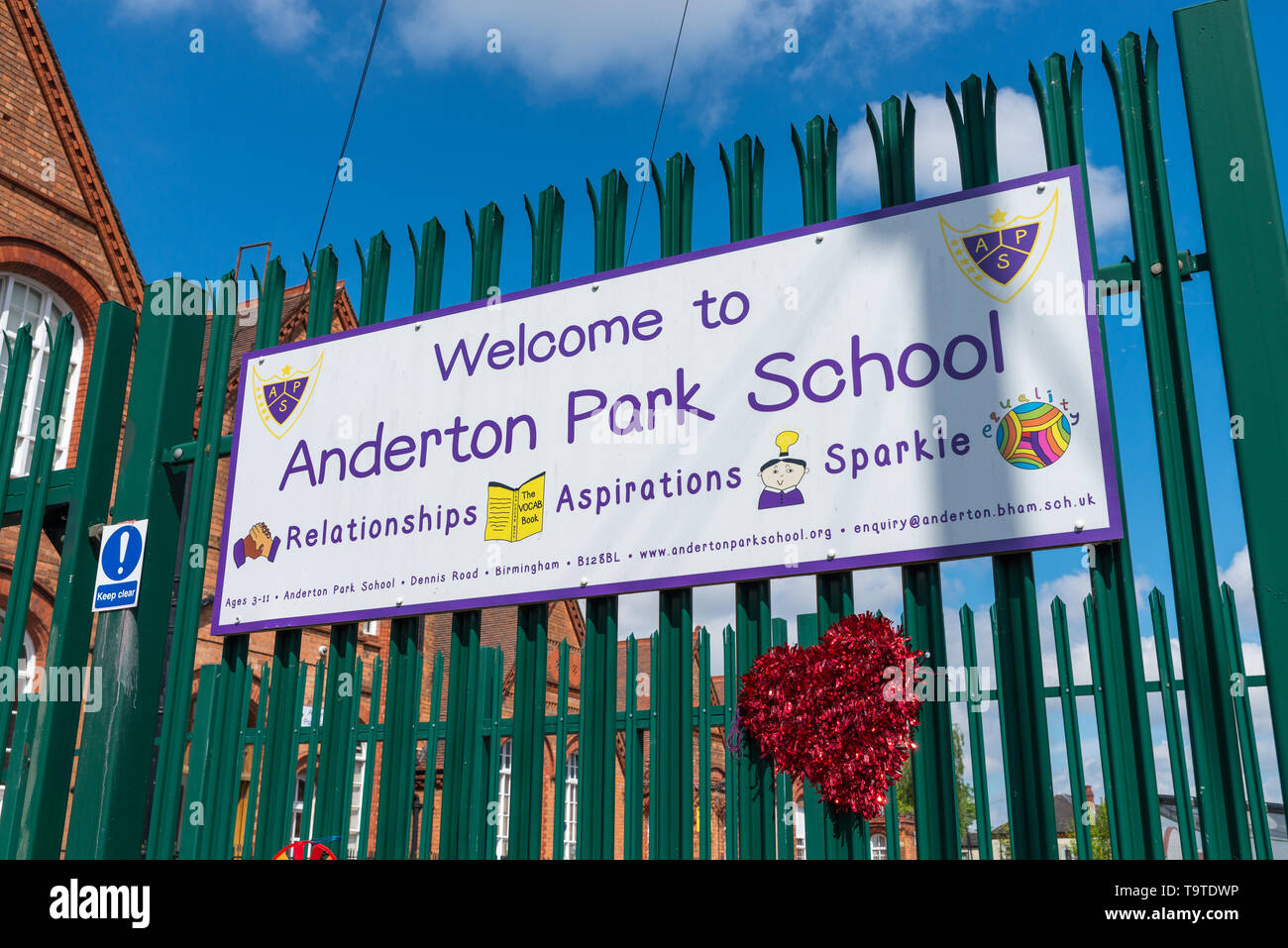 I musulmani contrari alle lezioni di LGBT si scontrarono con i sostenitori LGBT come essi attaccato arcobaleno banner colorati a ringhiera a Radlett Park School, Birmingham Foto Stock