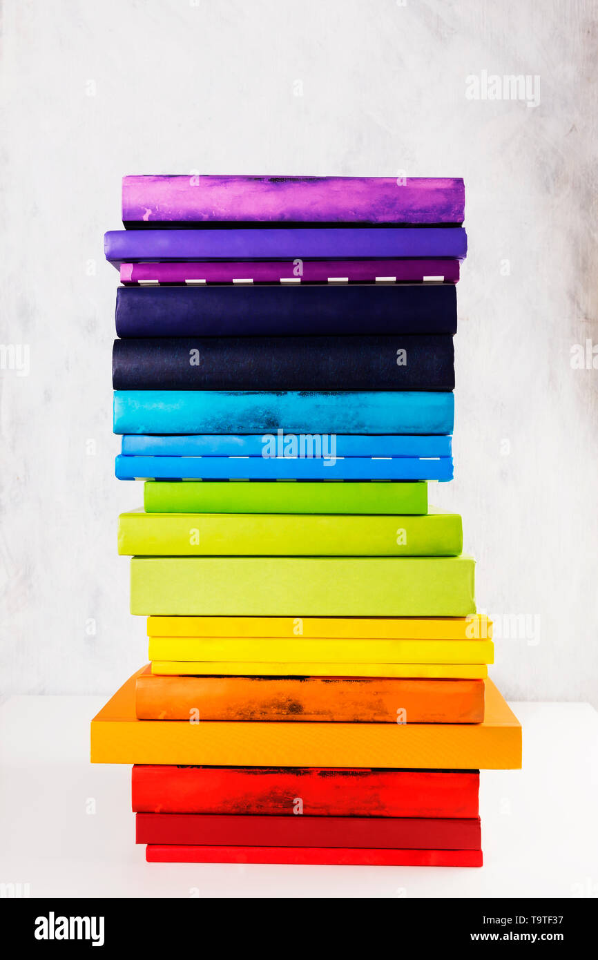 Pila di arcobaleno colorato libri su sfondo bianco Foto Stock