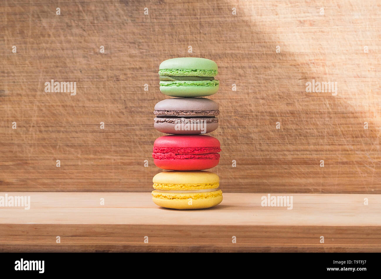 Quattro gustosi colorati macarons francese isolato su texture di legno Foto Stock