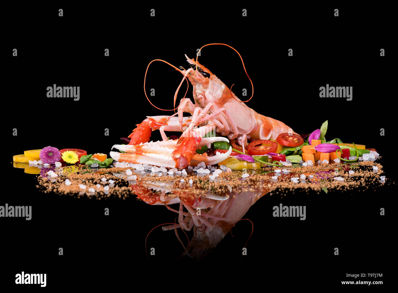 Materie scampi con verdure su uno sfondo nero con la riflessione Foto Stock