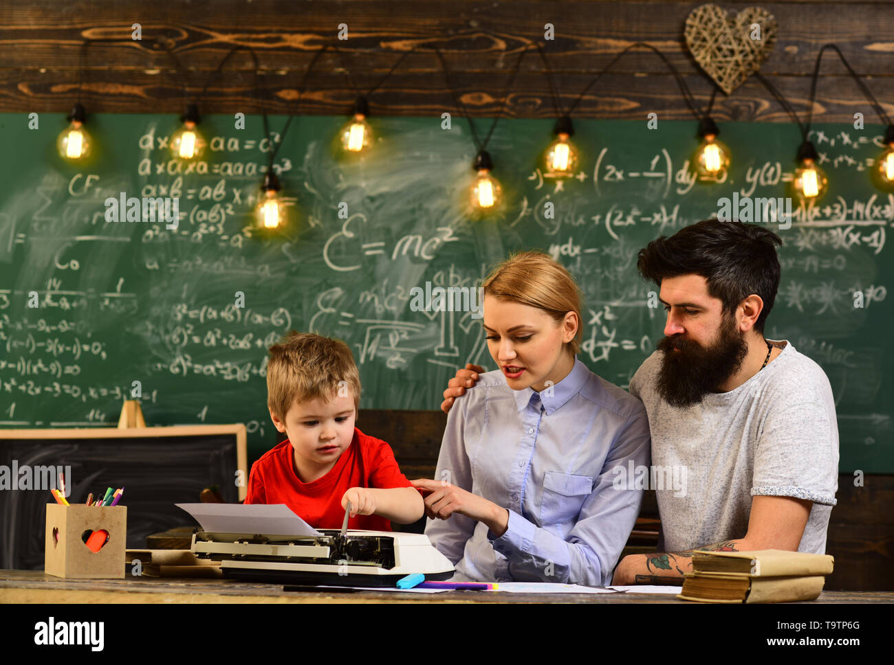 Insegnante o tutor aiuta bambini in età prescolare, uomo cerca nel display del computer portatile a guardare il corso di formazione e di ascolto, insegnante mette segna Invia feedback su Foto Stock