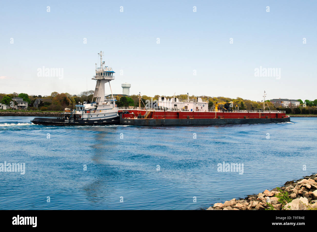 Rimorchiatore spinge una chiatta del carburante attraverso il canale di Cape Cod con il blu del cielo e acqua Foto Stock