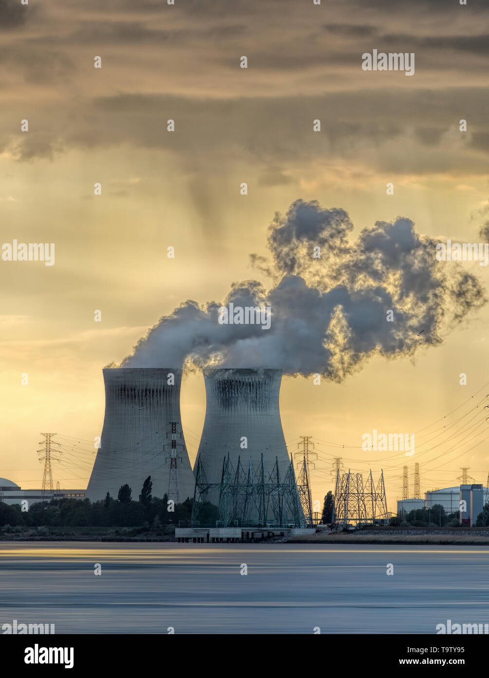 Riverbank con un impianto ad energia nucleare Doel durante un tramonto con drammatica cluds, porto di Anversa, Belgio Foto Stock