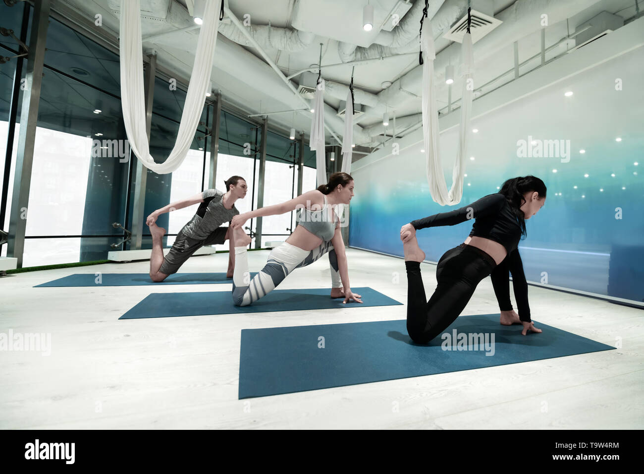 Uomo e donna di tenere i loro piedi mentre si estende facendo yoga Foto Stock