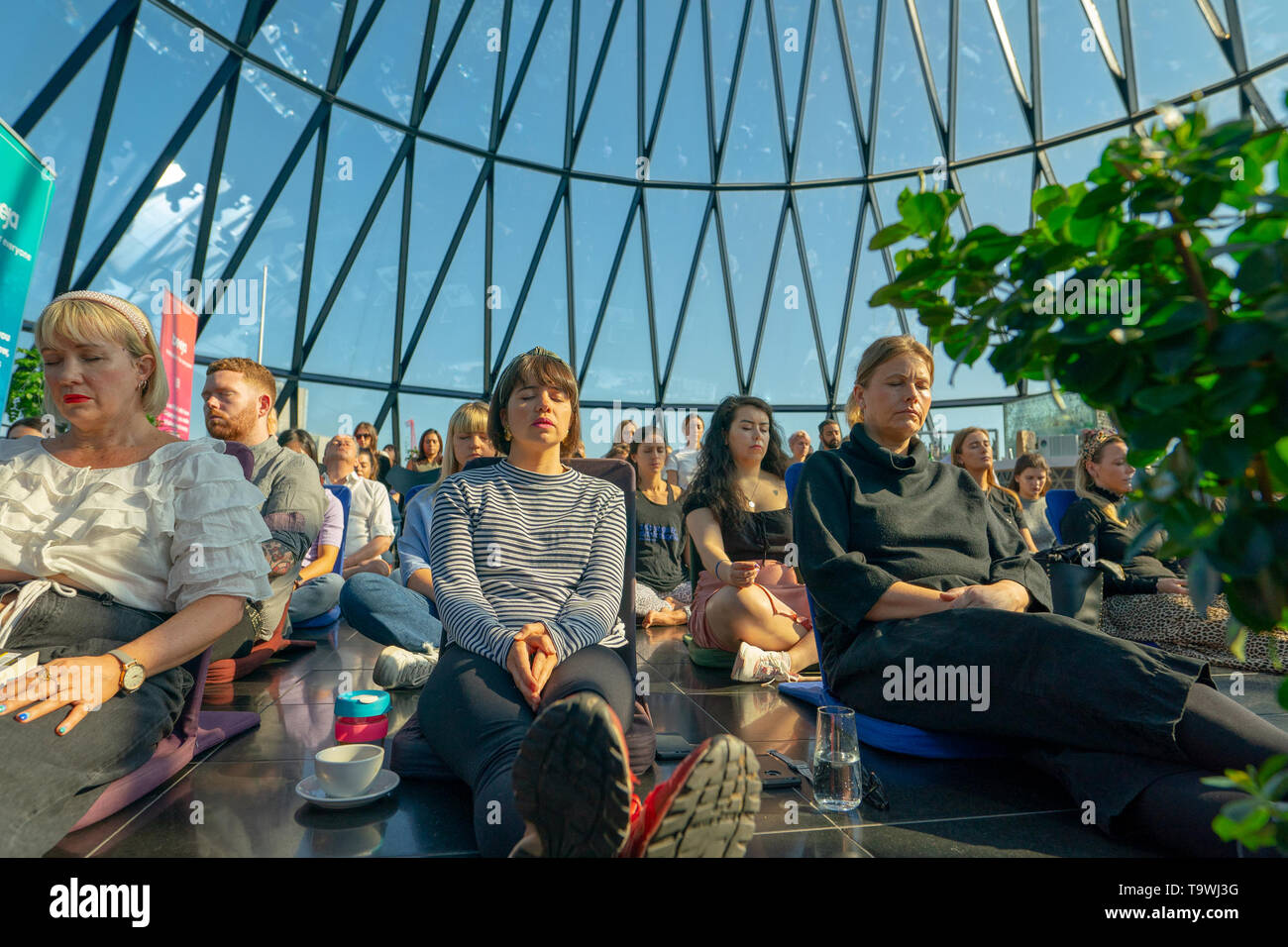 Londra, Regno Unito. 21 Maggio, 2019. La Meditazione Beeja gruppo ospitando una meditazione guidata sessione in Searcys bar in cima all'Gerkin blocco uffici a Londra per contrassegnare il mondo meditazione giorno. Foto Data: martedì 21 maggio, 2019. Foto: Roger Garfield/Alamy Credito: Roger Garfield/Alamy Live News Foto Stock