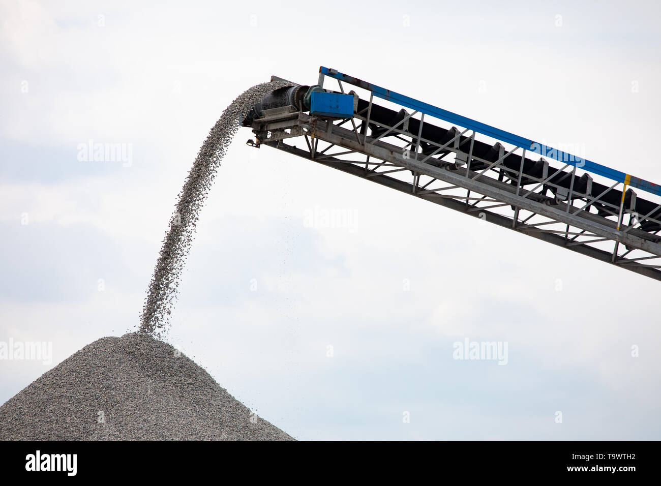 Industria nazionale internazionale spedizione trasportatore telescopico di movimento del nastro di materiale di roccia su un riverfront itinerario di spedizione Foto Stock