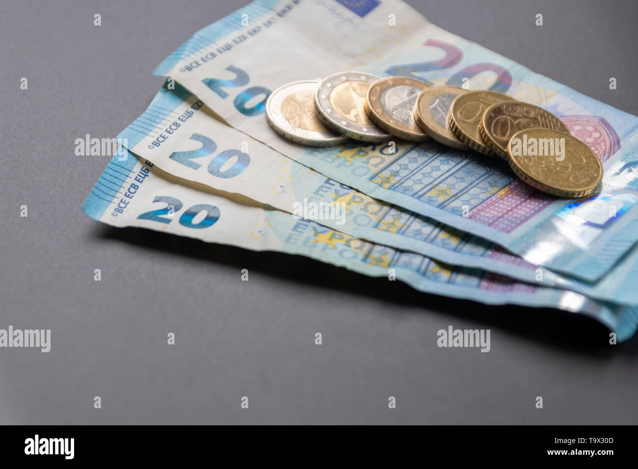 Una pila di banconote da 20 euro con 2 monete da euro, 1 monete da euro e 50 cent è pronta per il pagamento, in contanti europei o in tasca per investimenti privati Foto Stock