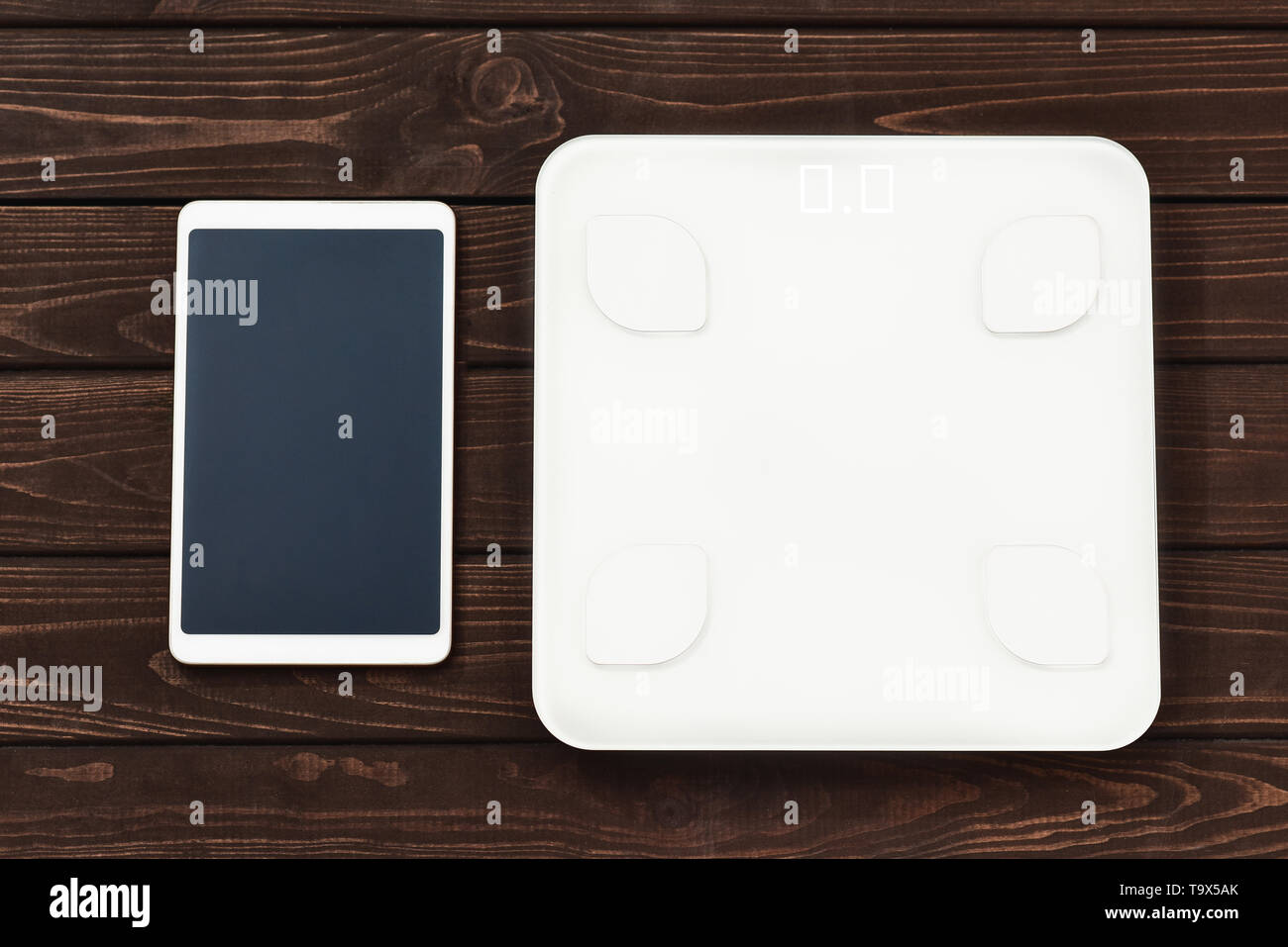 Indice Glicemico Fitness e perdita di peso concetto, scala bianca e tablet sul tavolo di legno, vista dall'alto, Foto Stock