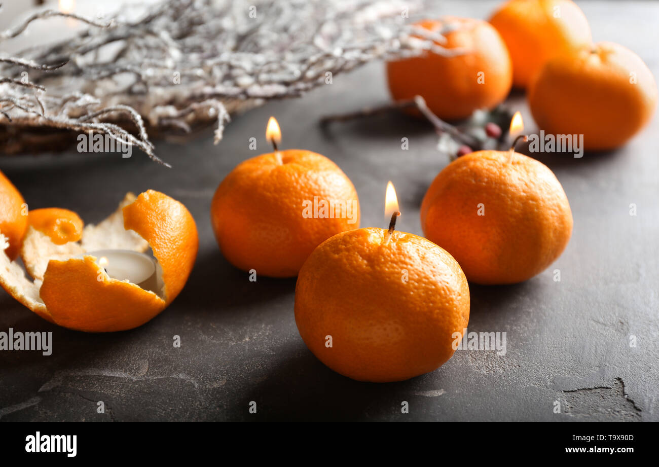 Tangerini con candela che brucia stoppini sulla tabella di grunge Foto Stock