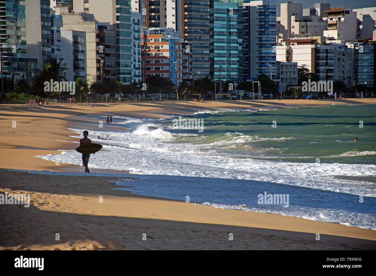 La sabbia del surfista gode di una spiaggia urbana, Praia da Costa, Vila Velha, Espirito Santo, Brasile Foto Stock