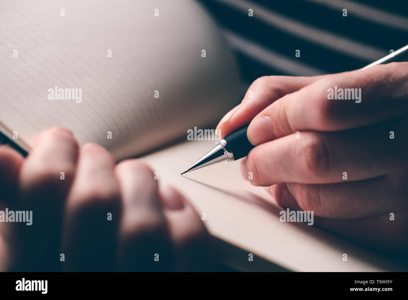 Mancino donna diario di scrittura, la stretta di mano con matita e notebook Foto Stock