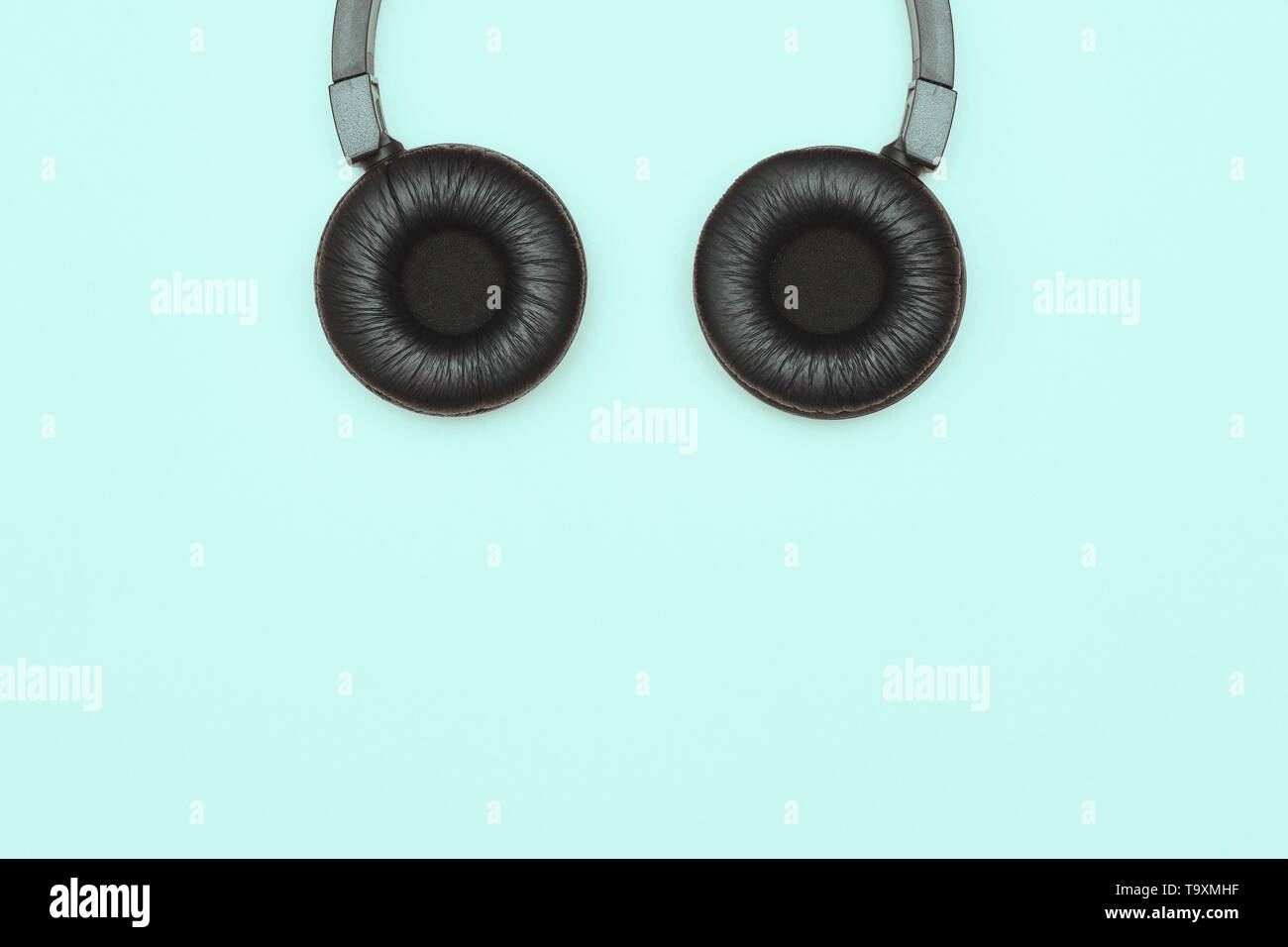Nero moderne cuffie wireless su uno sfondo blu. Il concetto di musica e moda. Minimalismo. copia spazio. spazio per il testo Foto Stock