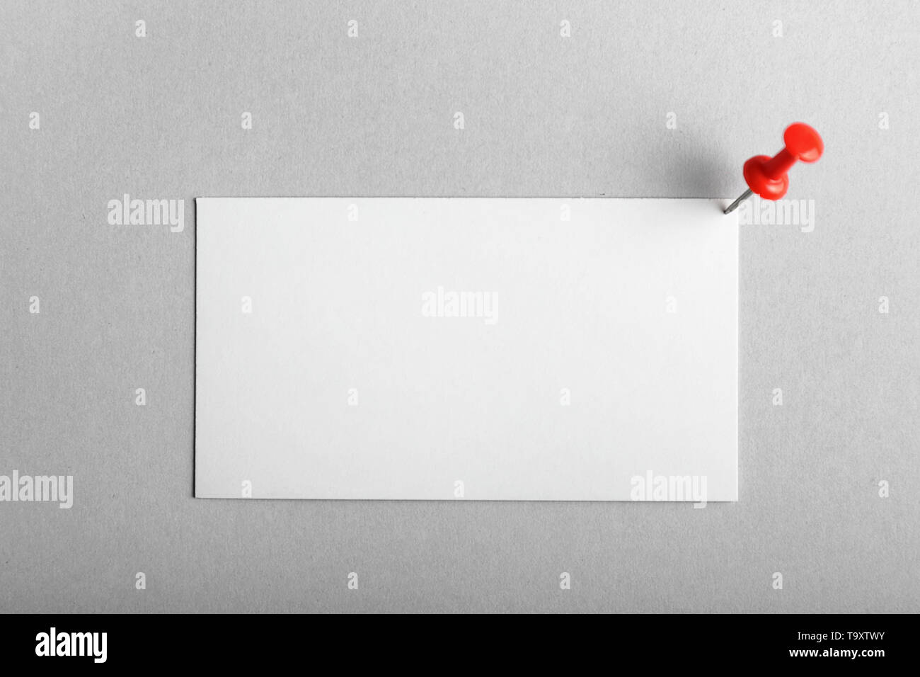 Blank business card e la puntina da disegno su sfondo chiaro Foto Stock