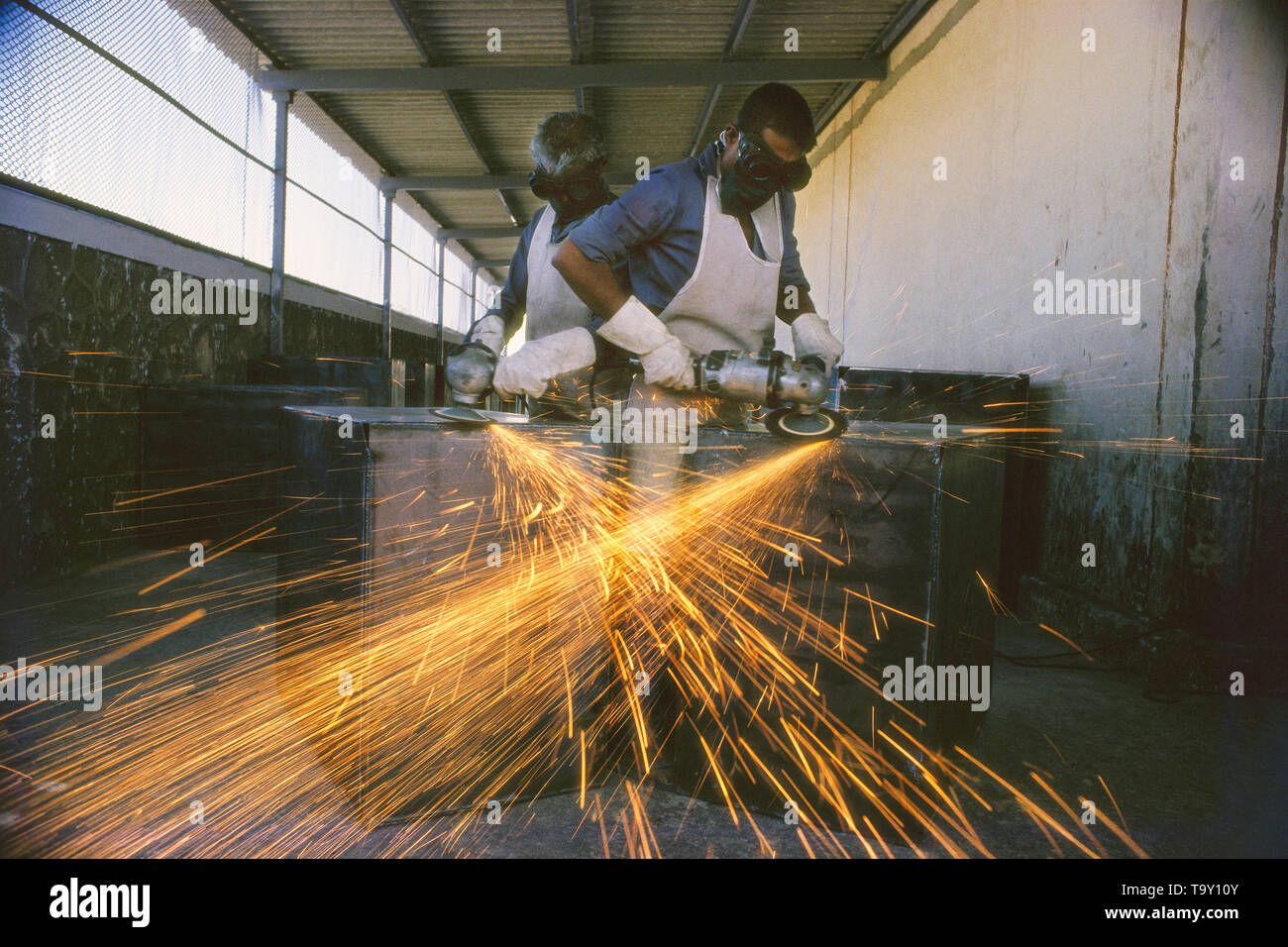 I LAVORATORI DI LEVIGATURA piastre di ferro in una fabbrica, INDIA Foto Stock