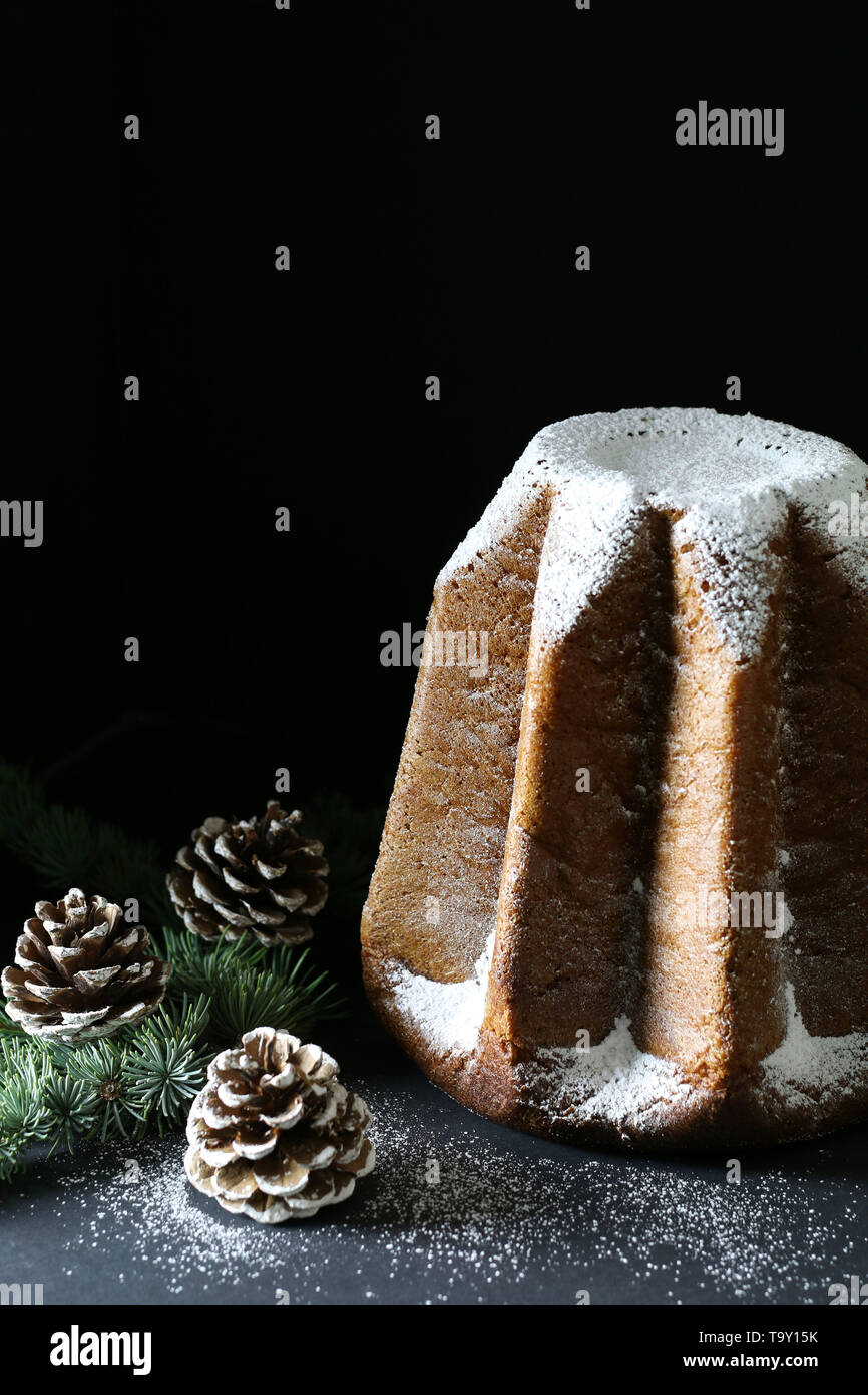 L'Italiano tradizionale di dolci di Natale. Pandoro italiano tradizionale torta di Natale su sfondo scuro. Le decorazioni di Natale Foto Stock