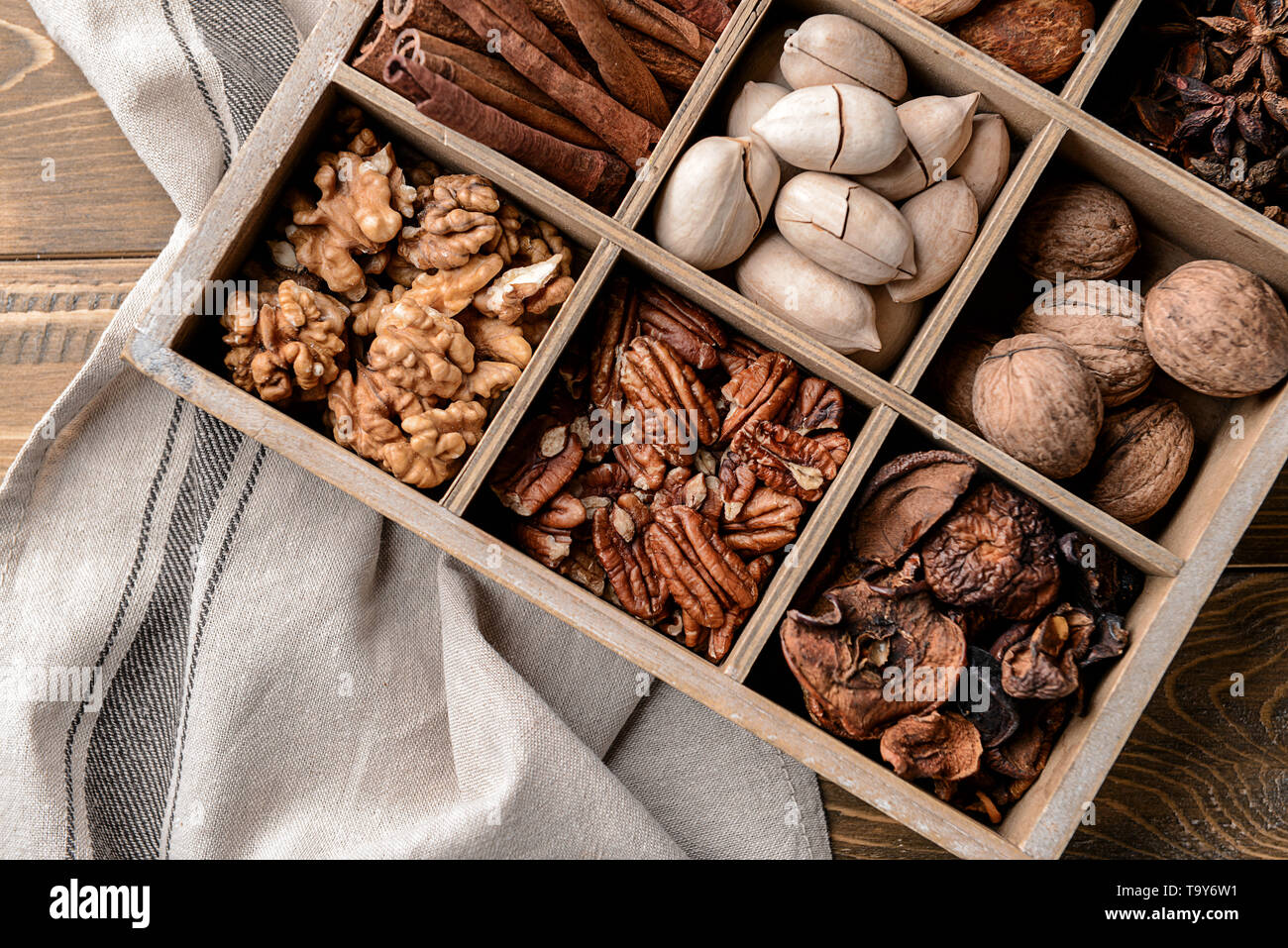 Assortimento di frutta e spezie in divisa casella sul tavolo Foto Stock