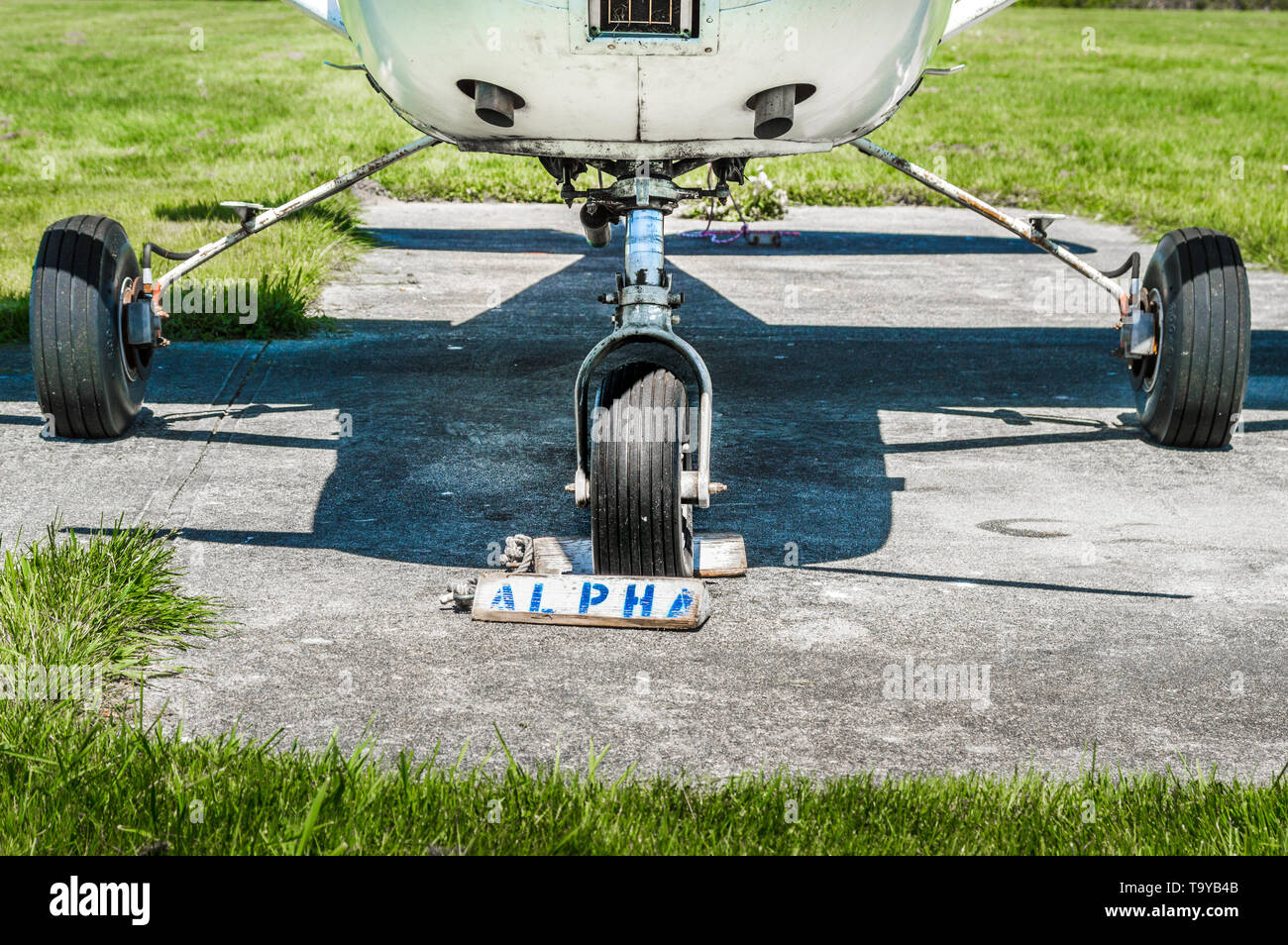 Piccolo motore unico vecchio aereo ruote e carrello di atterraggio sulla  piazzola di parcheggio con i cunei per ruote sulla giornata di sole Foto  stock - Alamy