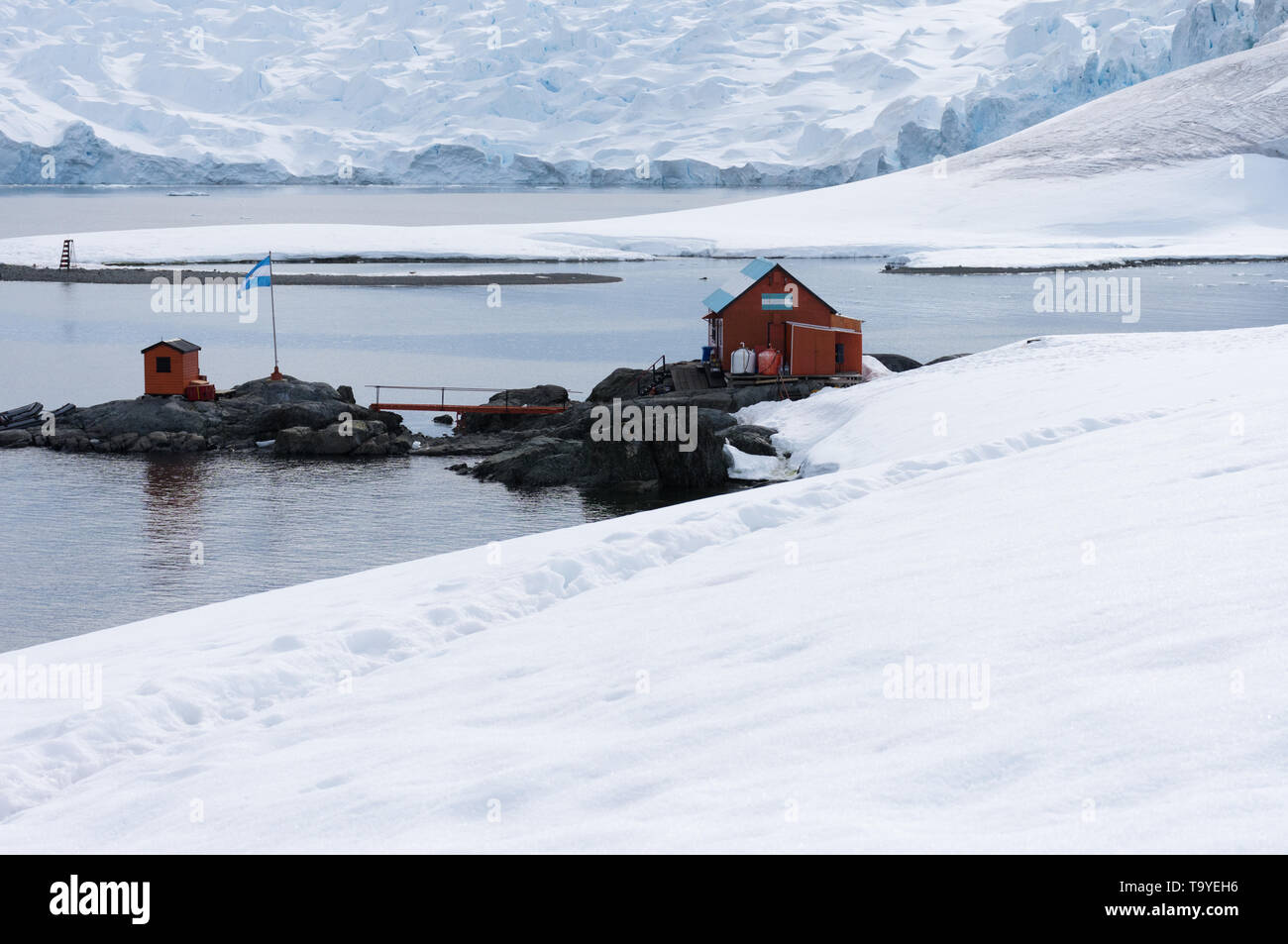 Camp Brown, un argentino base di ricerca in Antartide con la neve in primo piano e ghiacciai e acqua in background. Foto Stock