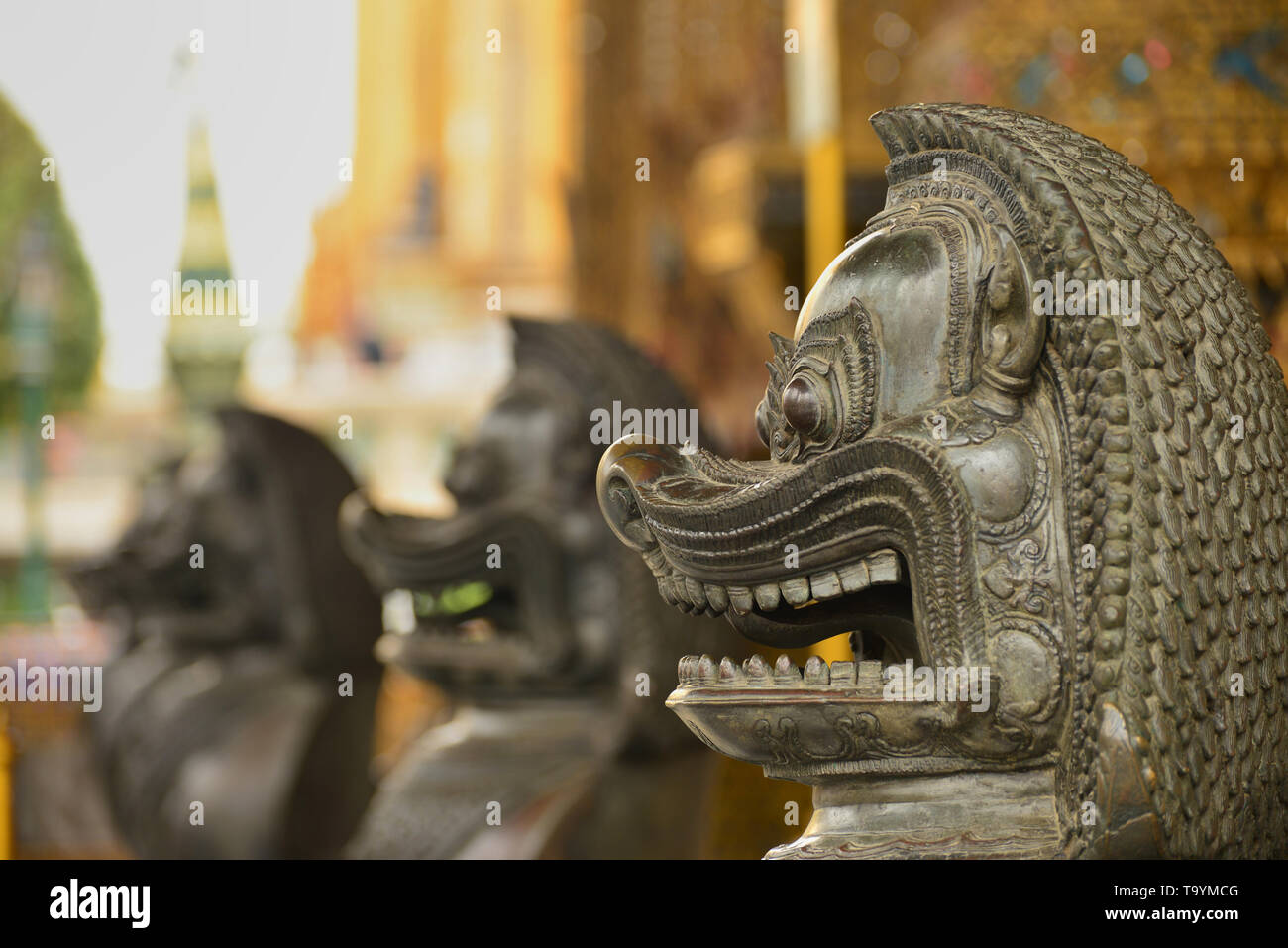 Primo piano delle statue di leone in pietra al Grand Palace di Bangkok Foto Stock