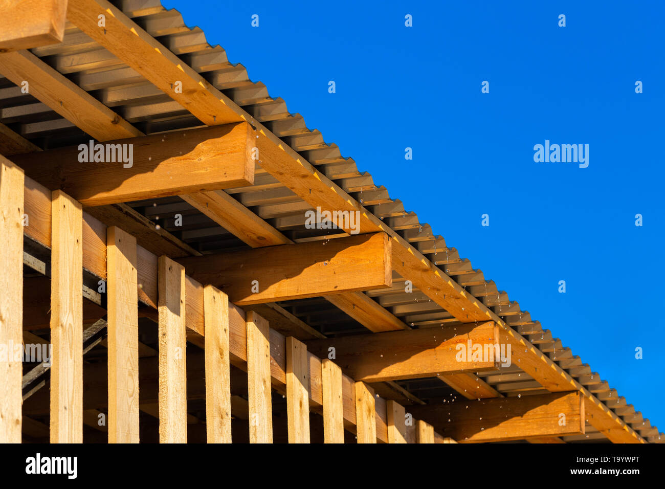 gocce d'acqua sorgiva che volano dal bordo del tetto del fienile Foto Stock