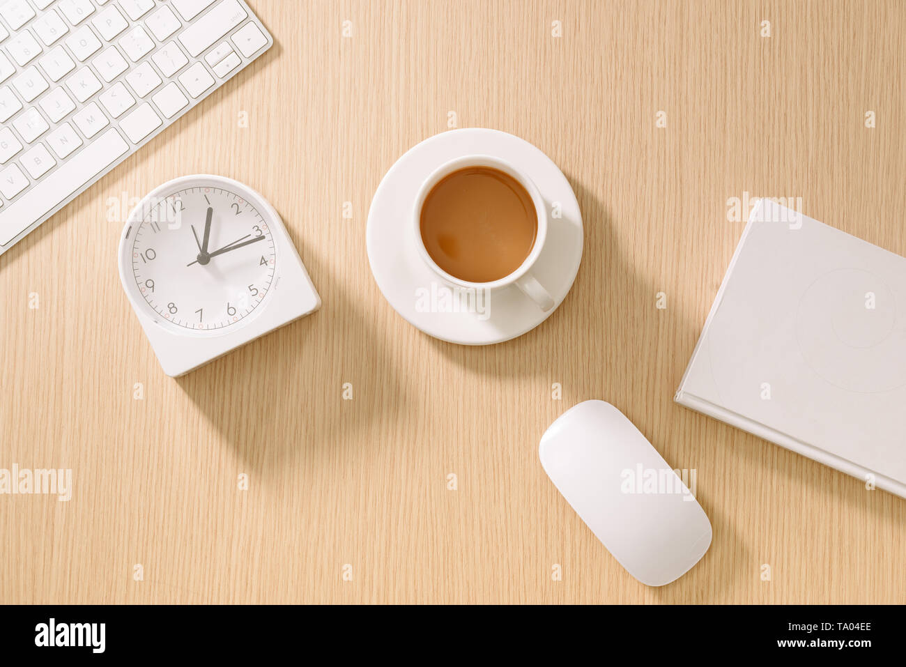 Bianca e moderna scrivania da ufficio con tastiera, mouse, notebook, orologio e la tazza di caffè. Vista da sopra con copia incolla. Attività e strategia concetto mockup. Foto Stock