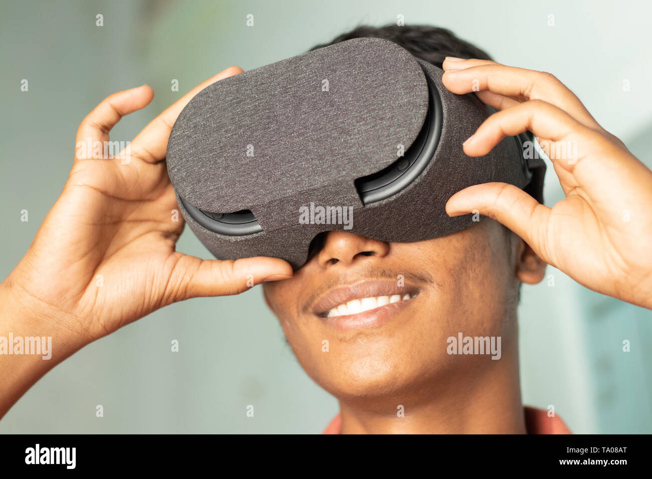 Primo piano di un giovane uomo sperimenta la realtà virtuale attraverso un auricolare VR Foto Stock