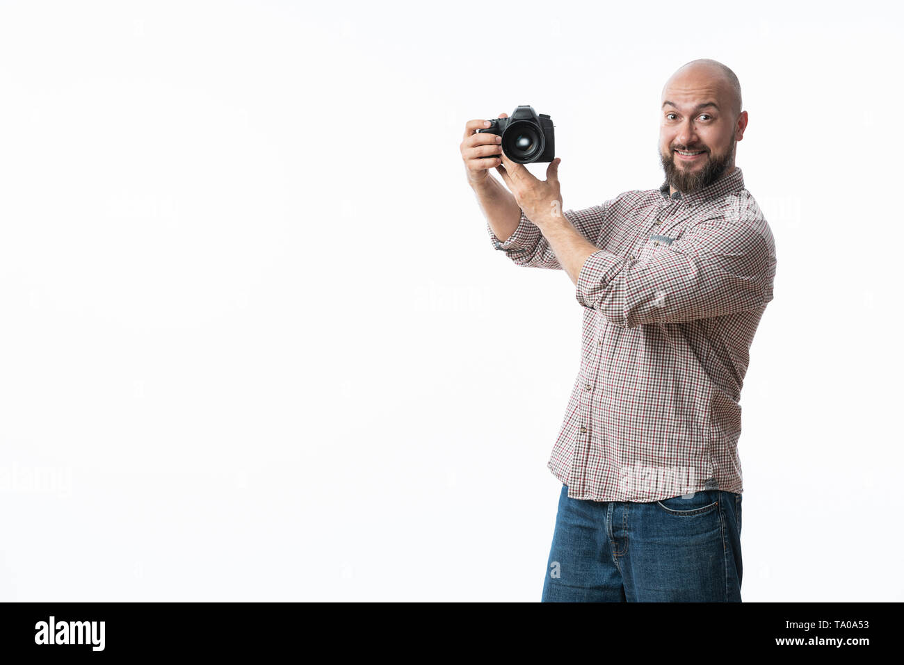 Giovane fotografo allegro con la barba, mentre lavora in studio Foto Stock
