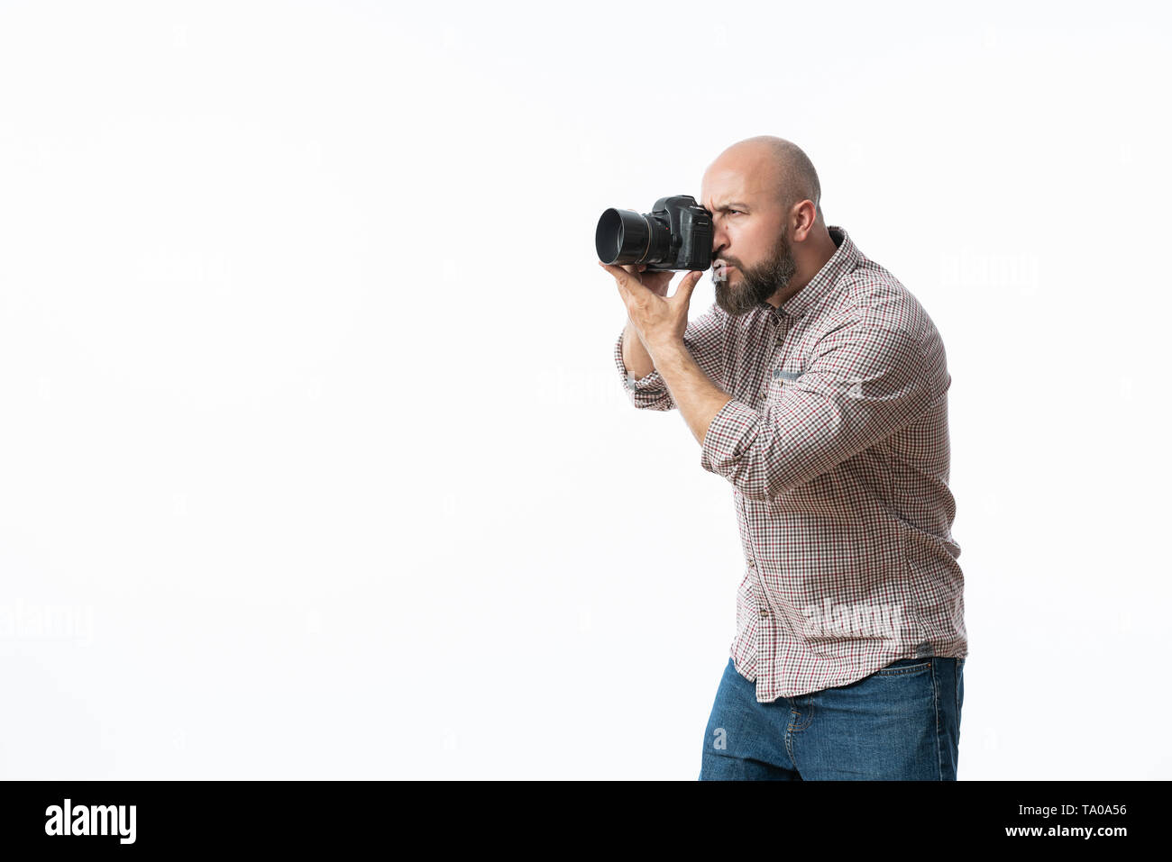 Giovane fotografo allegro con la barba, mentre lavora in studio Foto Stock
