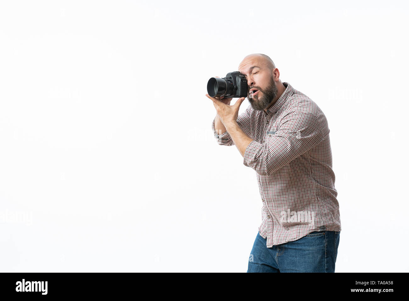 Giovane fotografo allegro con la barba, mentre lavora in studio Foto Stock