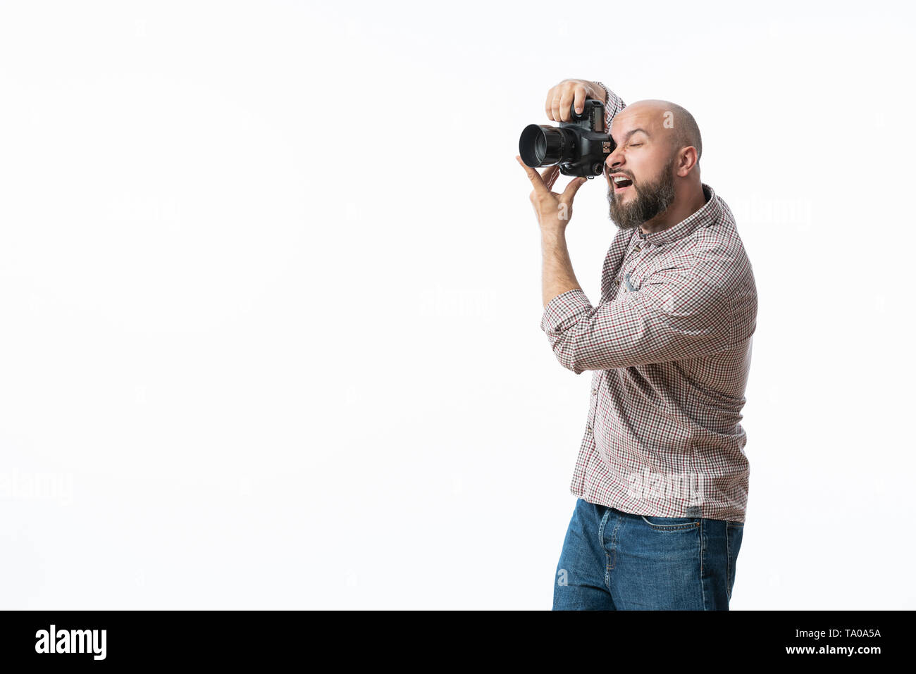 Giovane fotografo allegro con la barba, mentre lavora in studio Foto Stock
