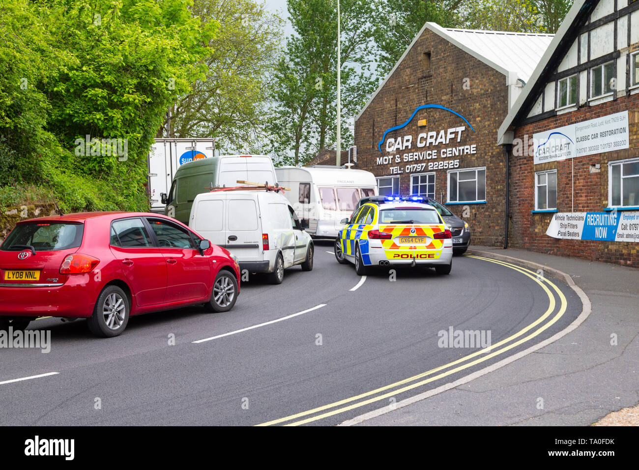 Auto della Polizia bloccati nel traffico con luci lampeggianti sulla A259, segala, east sussex, Regno Unito Foto Stock