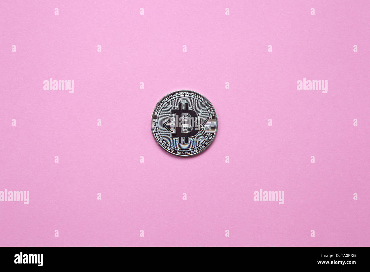 Argento bitcoin su una millenaria sfondo rosa. Vista dall'alto. Minimalismo. Orientamento orizzontale. Foto Stock