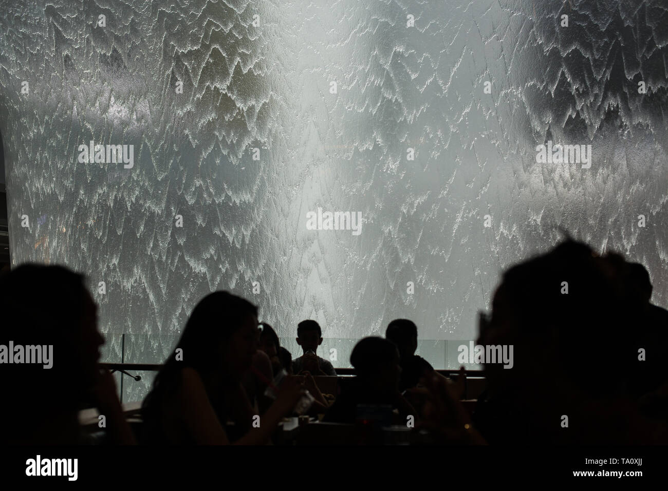 Potrete gustare il proprio pasto e raccogliere la pioggia cascata a vortice in Jewel Changi Airport. Foto Stock