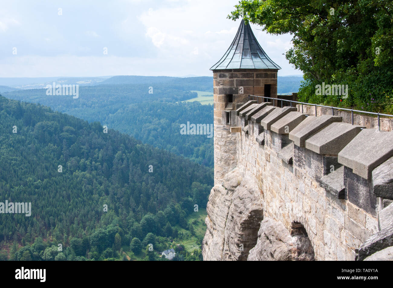 La parete di fortezza e la torre di un antico fortilizio medievale su una scogliera al di sopra della pianura. Foto Stock